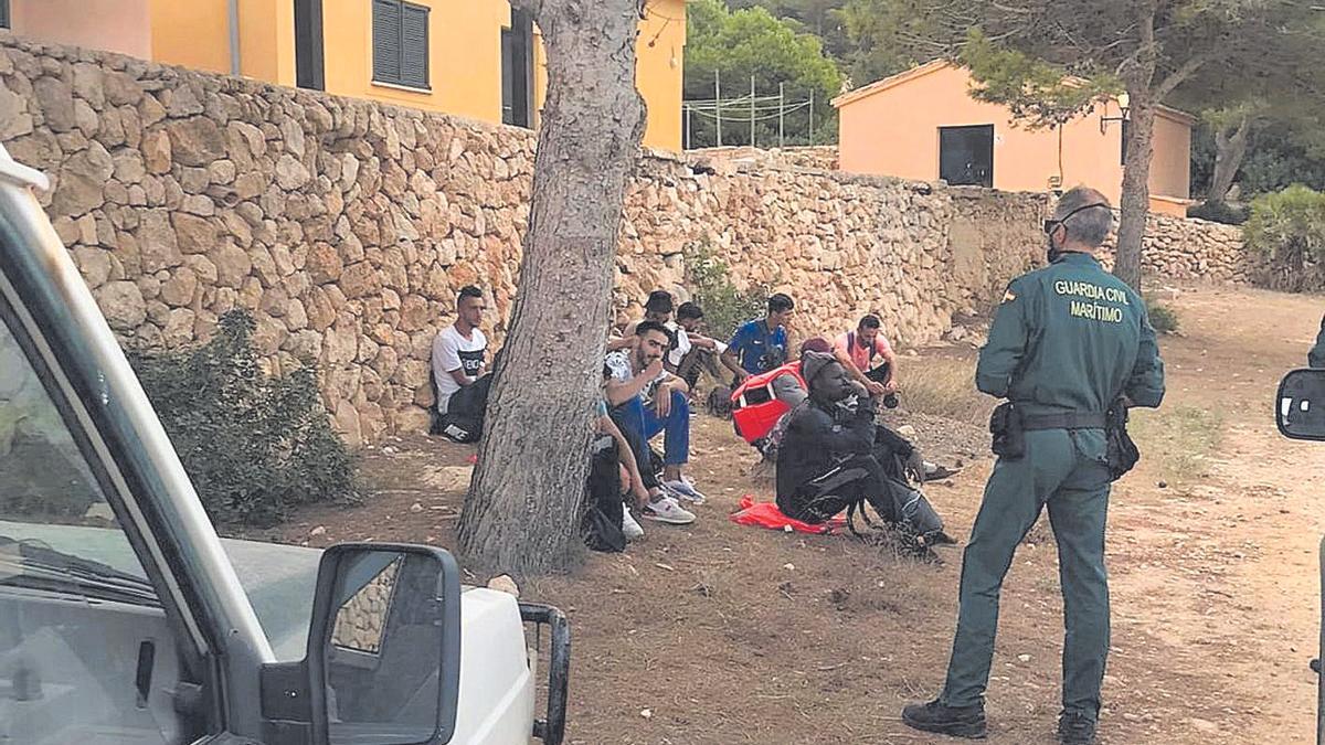 Agentes de la Guardia Civil custodian ayer a un grupo de personas llegadas a  Cabrera.