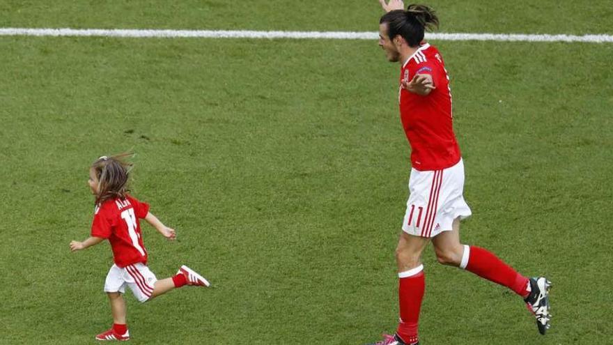 Bale, elegido el mejor jugador del partido, celebra sobre el césped con su hija la clasificación de Gales.