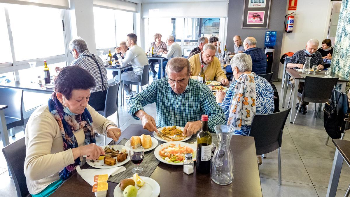 Un grupo de jubilados come en el restaurante de un hotel.
