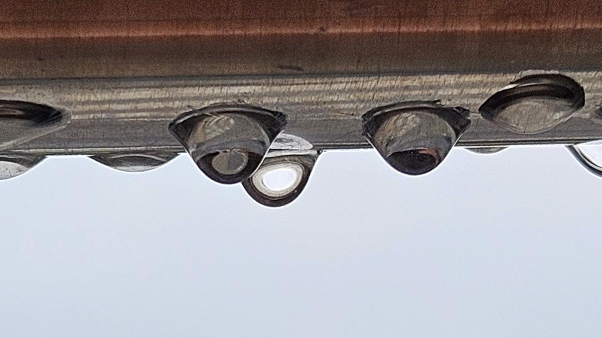 Gotes de pluja penjant d'una barana, a Sant Fruitós