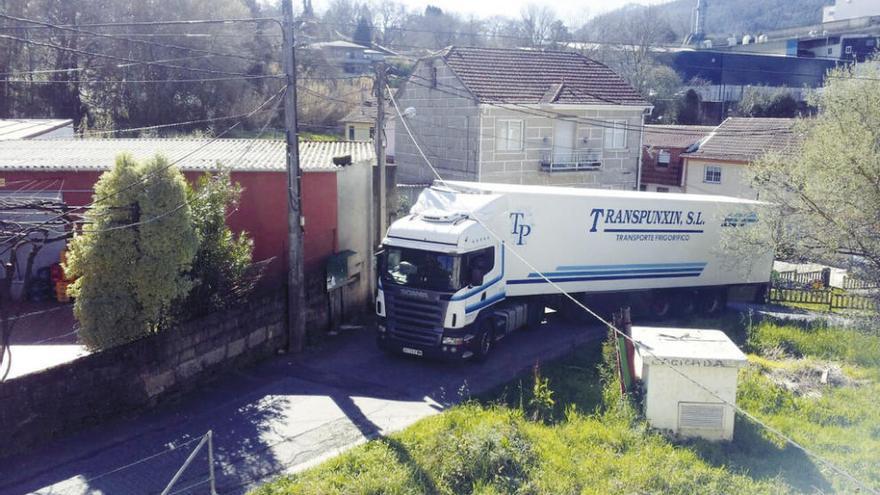 Un camión circula por las estrechas calles del barrio de A Portela.