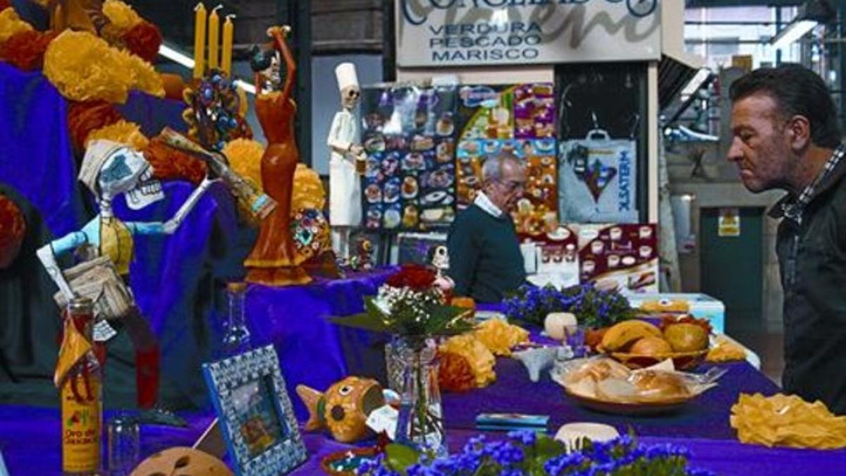 Dos visitantes, ayer, ante el altar creado por la mexicana Blanca Olea en el mercado del Galvany.