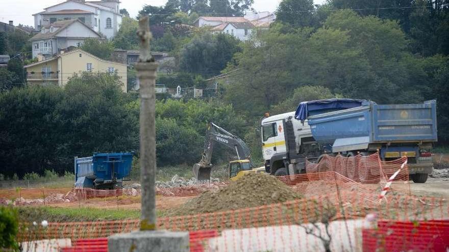 Obras de ampliación del aeropuerto cerca de las casas y con un cruceiro vallado, en 2011.