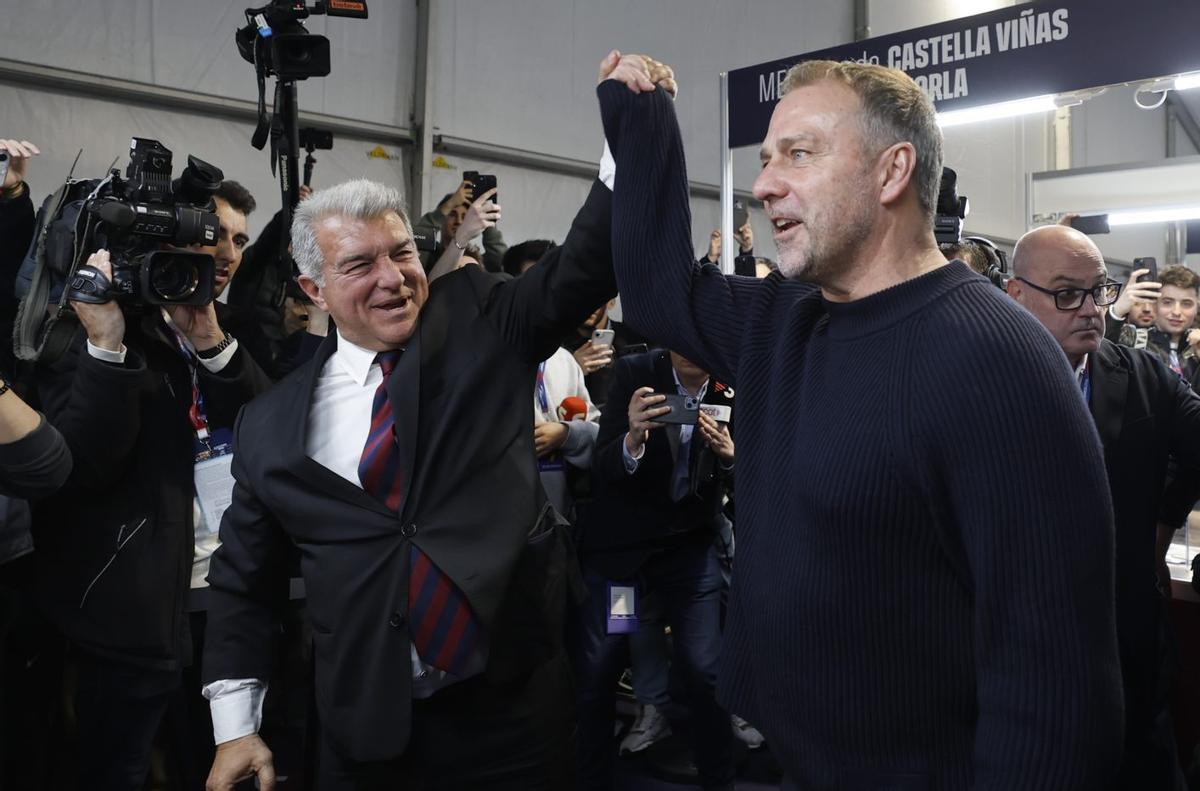 Laporta levanta el brazo de Flick mientras el técnico acudía a votar.