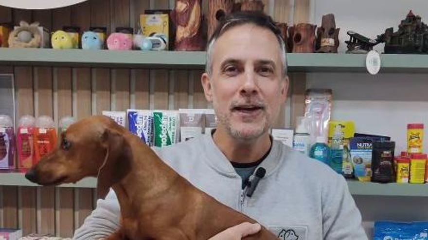 Mariano Martínez, veterinario, sosteniendo un perro salchicha.