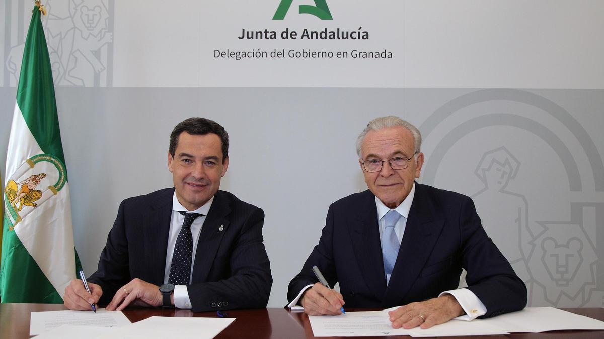 El presidente de la Junta de Andalucía, Juanma Moreno, y el presidente de la Fundación &quot;la Caixa&quot;, Isidro Fainé, en la firma del convenio marco entre ambas instituciones en Granada.