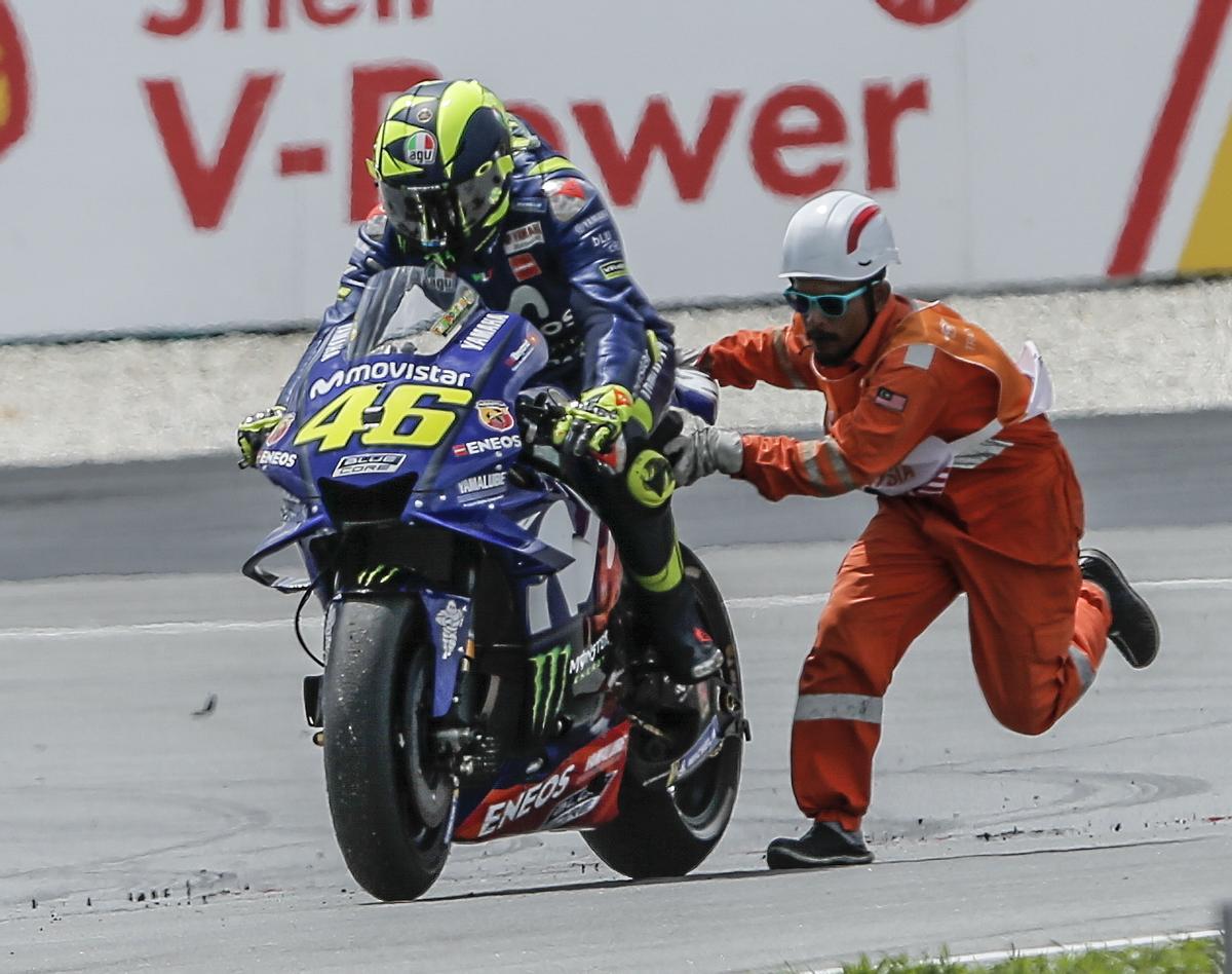 Un operario empuja a il dottore en el GP de Sepang 2018.