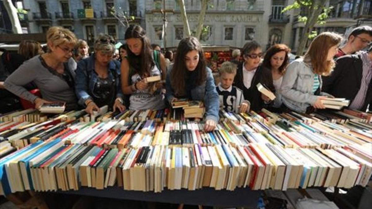 Ciudadanos ante una parada de libros en la Diada de Sant Jordi.
