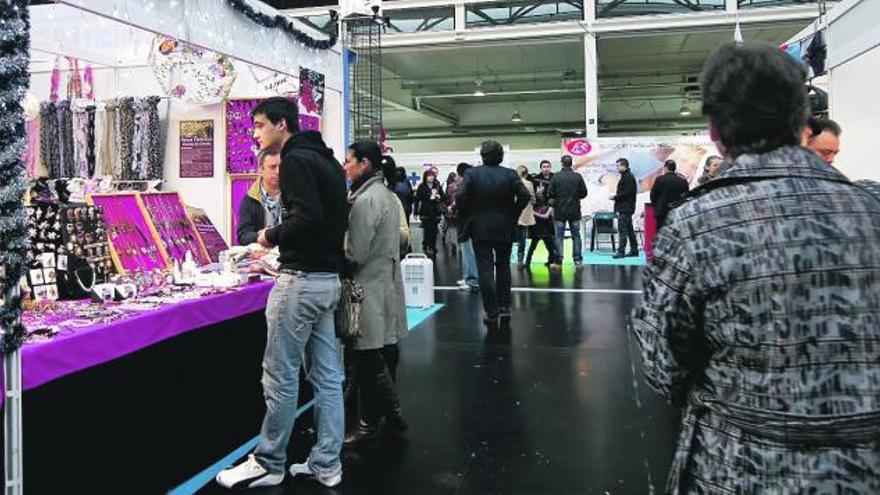 Visitantes en un expositor de joyas en la Feria de Muestras. / l. o.