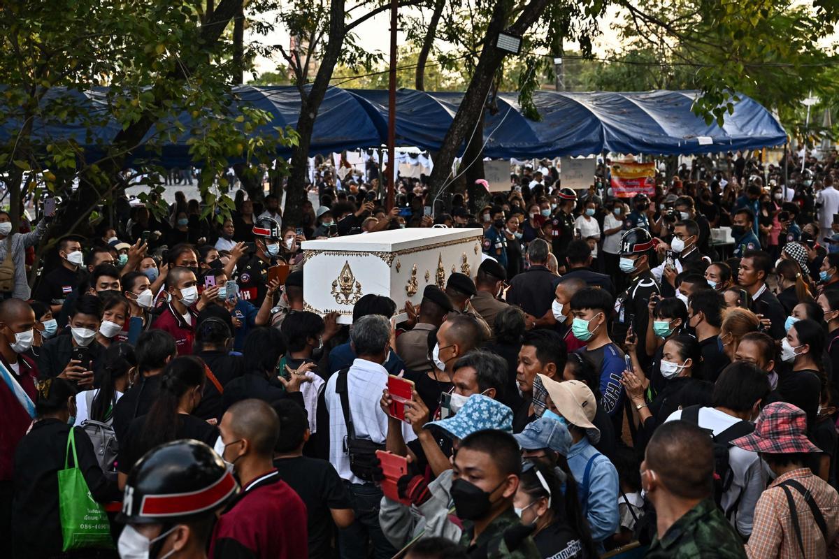 La gente observa cómo las piras funerarias incineran a 19 víctimas del tiroteo en la guardería de Uthai Suwan en el templo Wat Rat Samakee en Uthai Sawan. Un exoficial de policía disparó y mató a 37 personas, al menos 24 de ellos niños, después de irrumpir en una guardería infantil en el noreste de Tailandia.