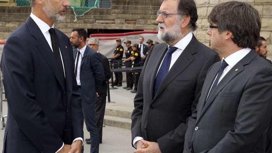 Felipe VI habla con Mariano Rajoy y Carles Puigdemont a su llegada a la Sagrada Familia para asistir a la misa por las víctimas de los atentados. // Efe