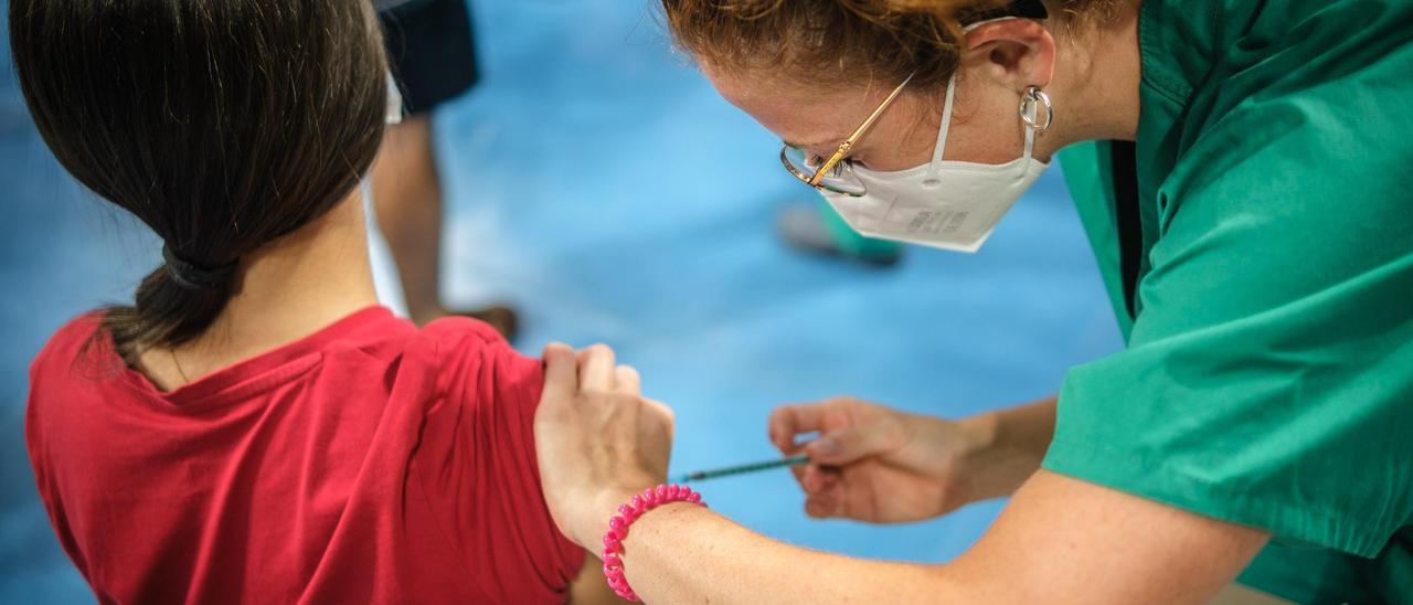 Una enfermera vacuna a una menor contra la covid-19 en el Pabellón Santiago Martín