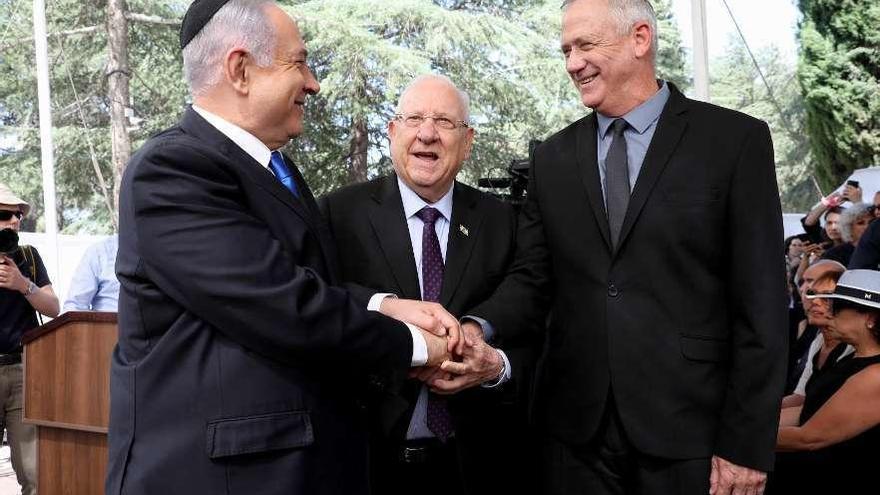 Netanyahu (a la izquierda) y Gantz, flanqueando a Rivlin, ayer en Jerusalén. // Efe