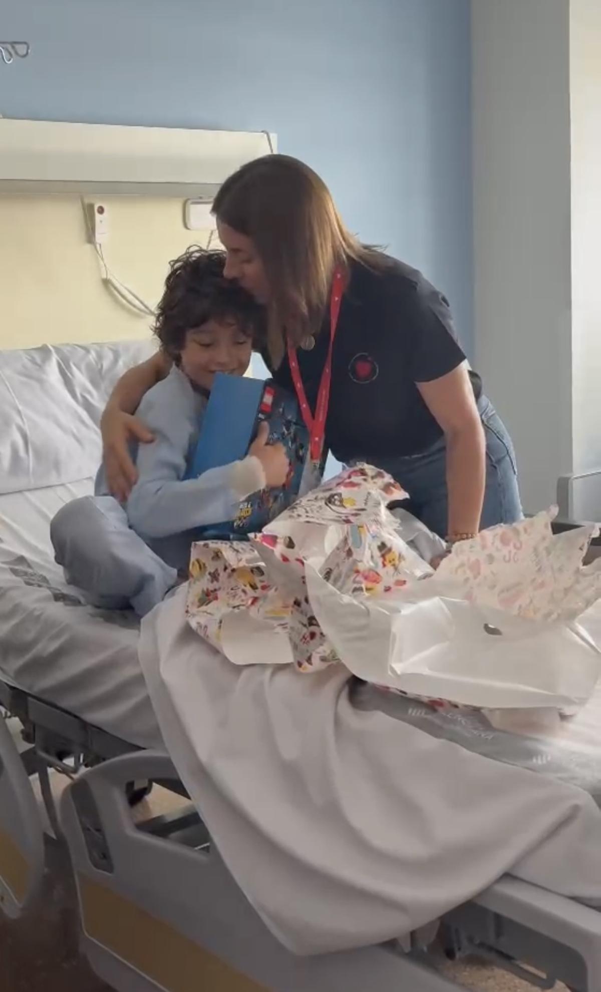 Majo Gimeno, de Mamás en Acción, abraza a un menor que está solo ingresado en el hospital.