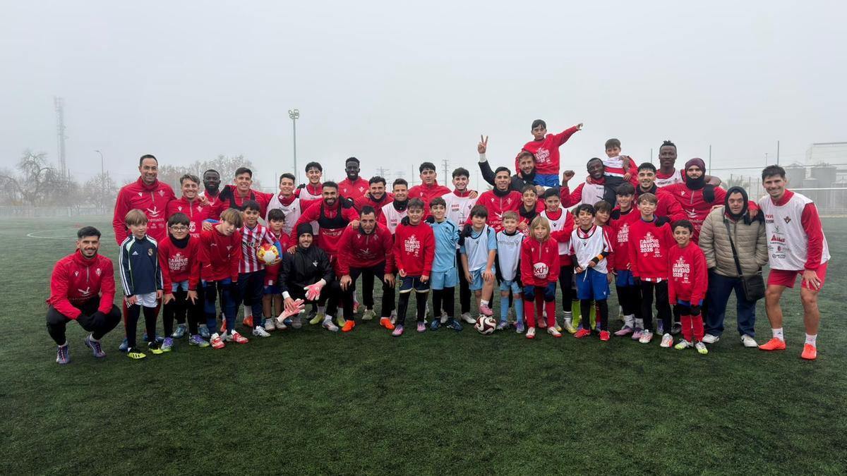 Jugadores del Don Benito, con jóvenes participantes en el campus navideño del club.