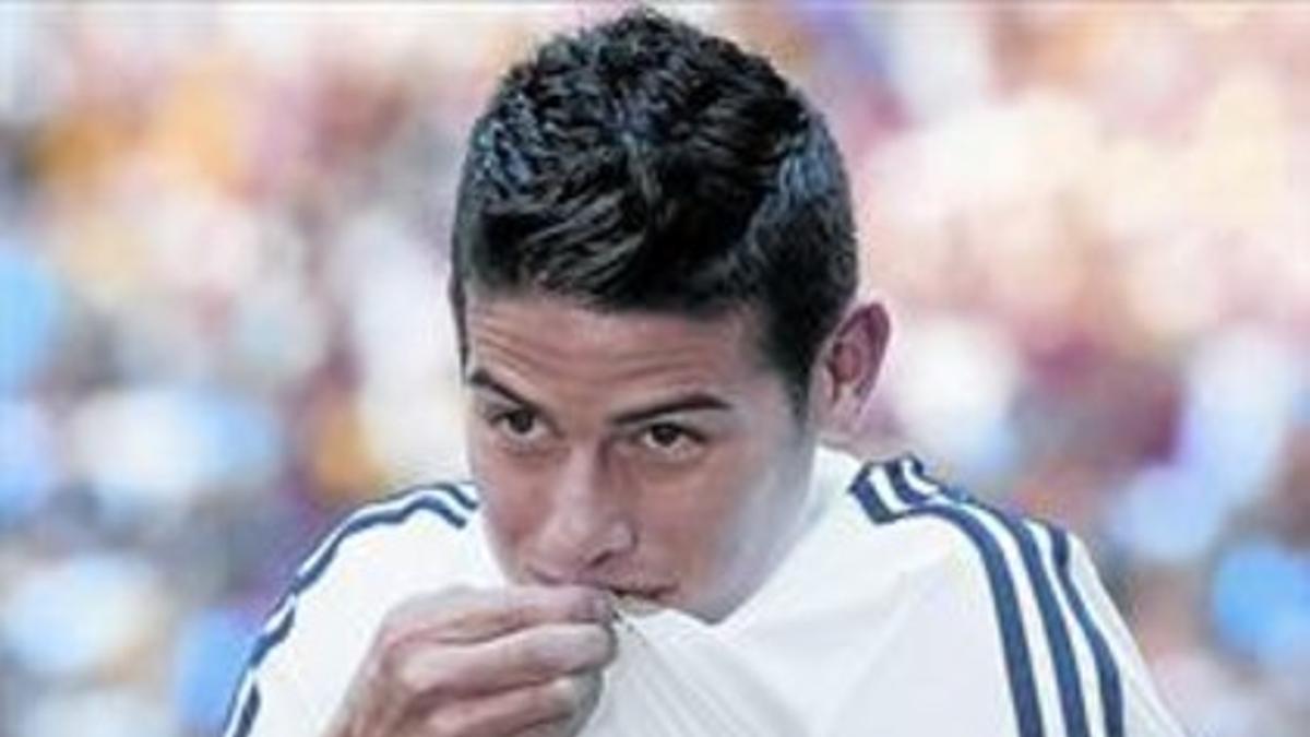 James Rodríguez besa el escudo durante la presentación de ayer en el Santiago Bernabéu.