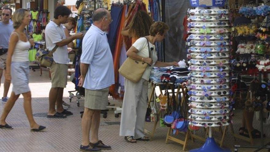 Turistas paseando por los puestos del puerto de Ibiza.