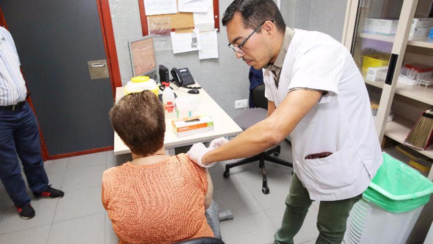 Un enfermero vacuna a una usuaria del centro de salud.