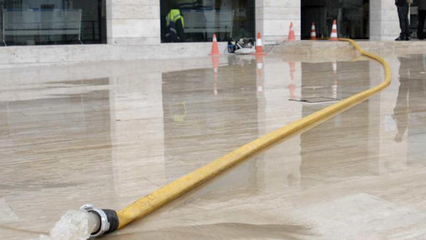 El Ayuntamiento amaneció aún anegado y hubo que achicar el agua con mangueras y ayuda de los Bomberos. A la derecha, el interior del consistorio, el exterior y el granizo el jueves por la noche.