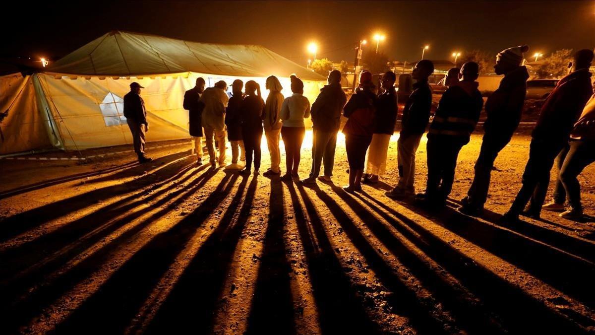 Votantes hacen cola frente a un local electoral antes del cierre de la votación, este miércoles en Johannesburgo.