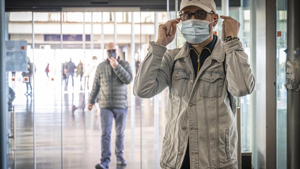 Una persona se coloca la mascarilla para entrar en el Hospital del Mar de Barcelona, este lunes.