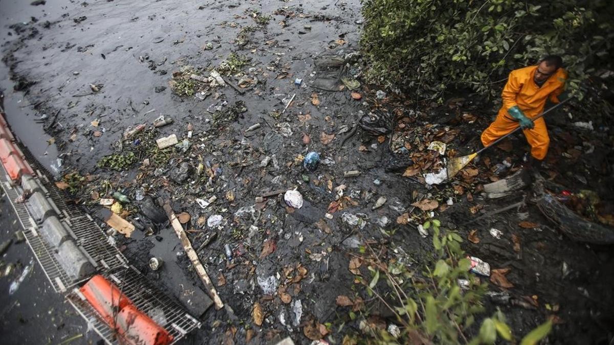 Un operario trabaja en la limpieza del río Meriti, que desemboca en la Bahía de Guanabara, sede de las pruebas olímpicas de vela.