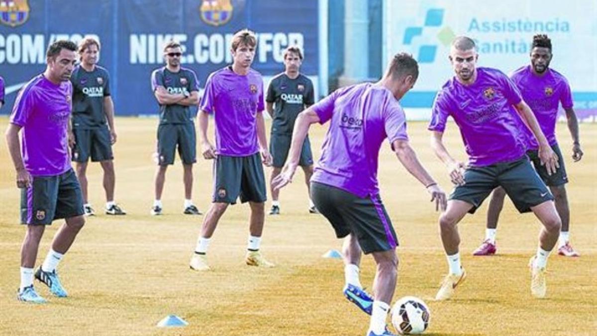 Rondo 8 Xavi (izquierda), durante la sesión de ayer en la ciudad deportiva, con Luis Enrique al fondo.