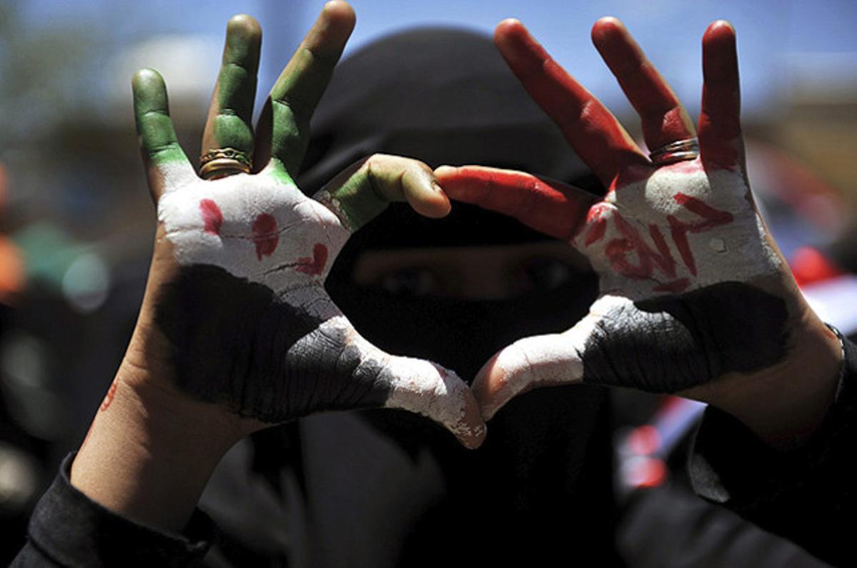 Una dona fa el símbol d’un cor durant una manifestació a Sanà (Iemen), per recordar els 18 assassinats en una protesta contra el Govern fa un any.