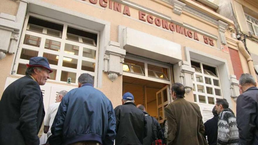 Usuarios de la Cocina Económica, en la puerta de la entidad benéfica.