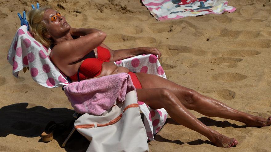 La imagen elegida por Reuters como icono mundial de la ola de calor en España, donde aparece una mujer tomando el sol en San Lorenzo.