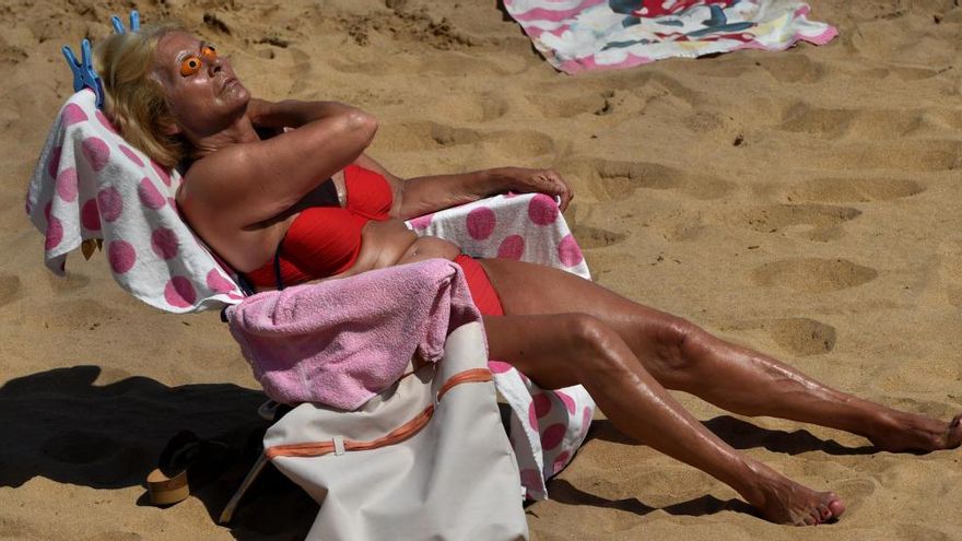 La imagen elegida por Reuters como icono mundial de la ola de calor en España, donde aparece una mujer tomando el sol en San Lorenzo.