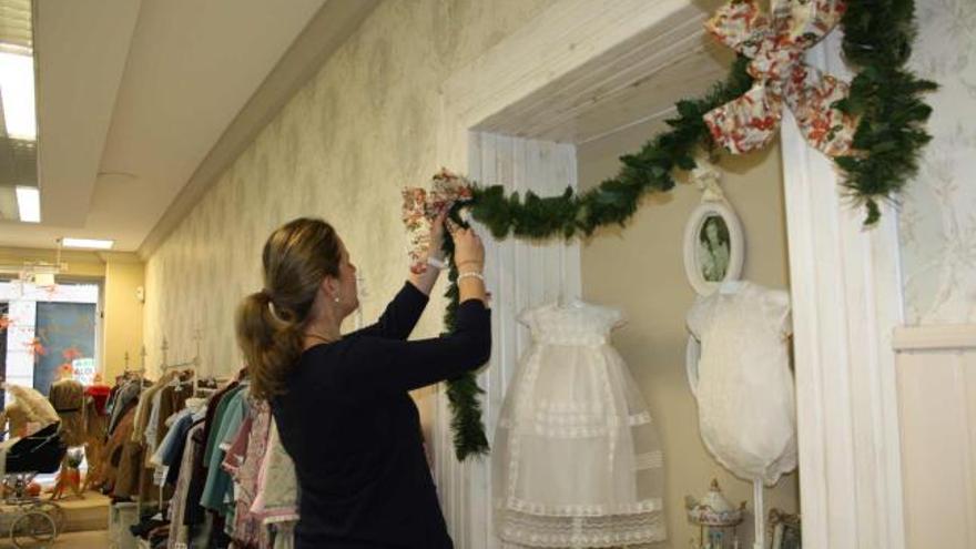 Ana Fuertes, decorando su negocio, en Luarca.