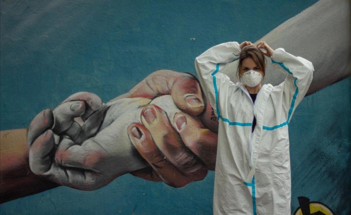 Helena Gines, fisioterapeuta en una residencia de mayores frente a un grafiti, en Barcelona.