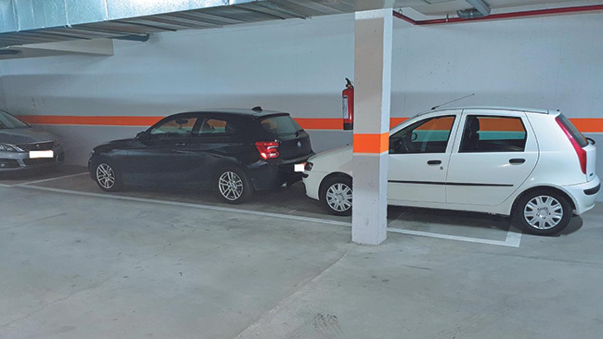 Ejemplo de lo que no se puede hacer en una plaza de párquing: ocupar más espacio del que hay delimitado.