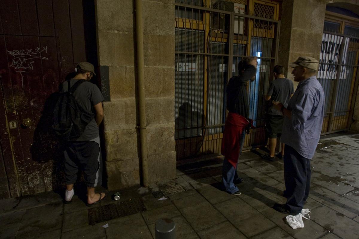 Un policía de paisano multa a un joven por orinar en la calle, entre otros dos que hacen lo mismo.