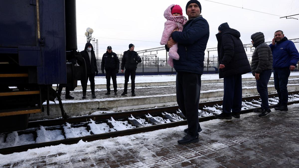 Un grupo de gente que huye de los ataques rusos en Ucrania espera para coger un tren hacia Polonia, en la estación de tren de Lviv