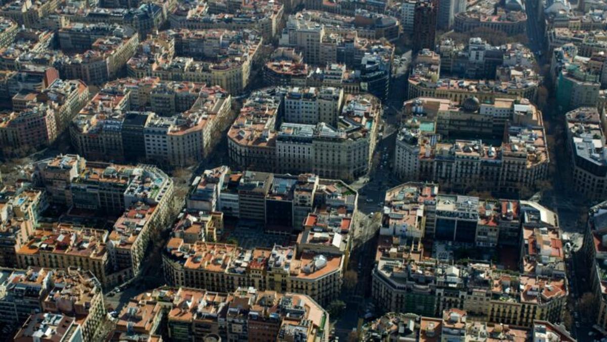 Vista aèria panoràmica de les illes de cases de lEixample, on saprecia la quadrícula del Pla Cerdà. Al fons, la Torre Urquinaona, edifici destil brutalista