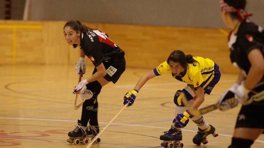 Marta Fernández pasa la bola a su compañera María Díez tras su perar a una rival.