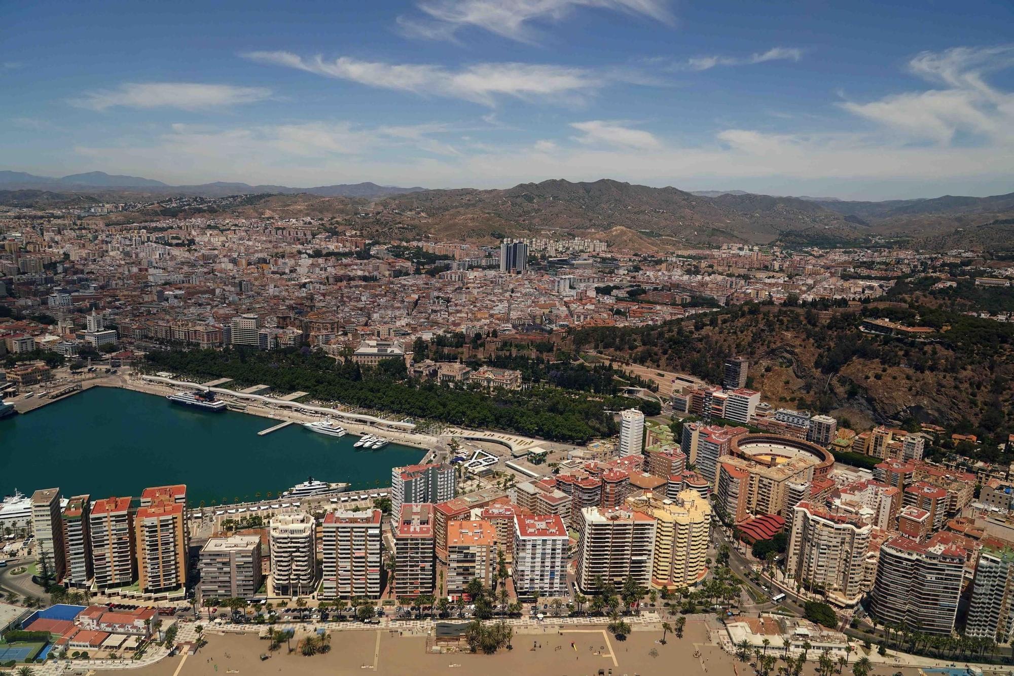 Vista aérea de Málaga capital que muestra La Malagueta, el Puerto, el Paseo del Parque, el Centro y al fondo las torres de Martiricos