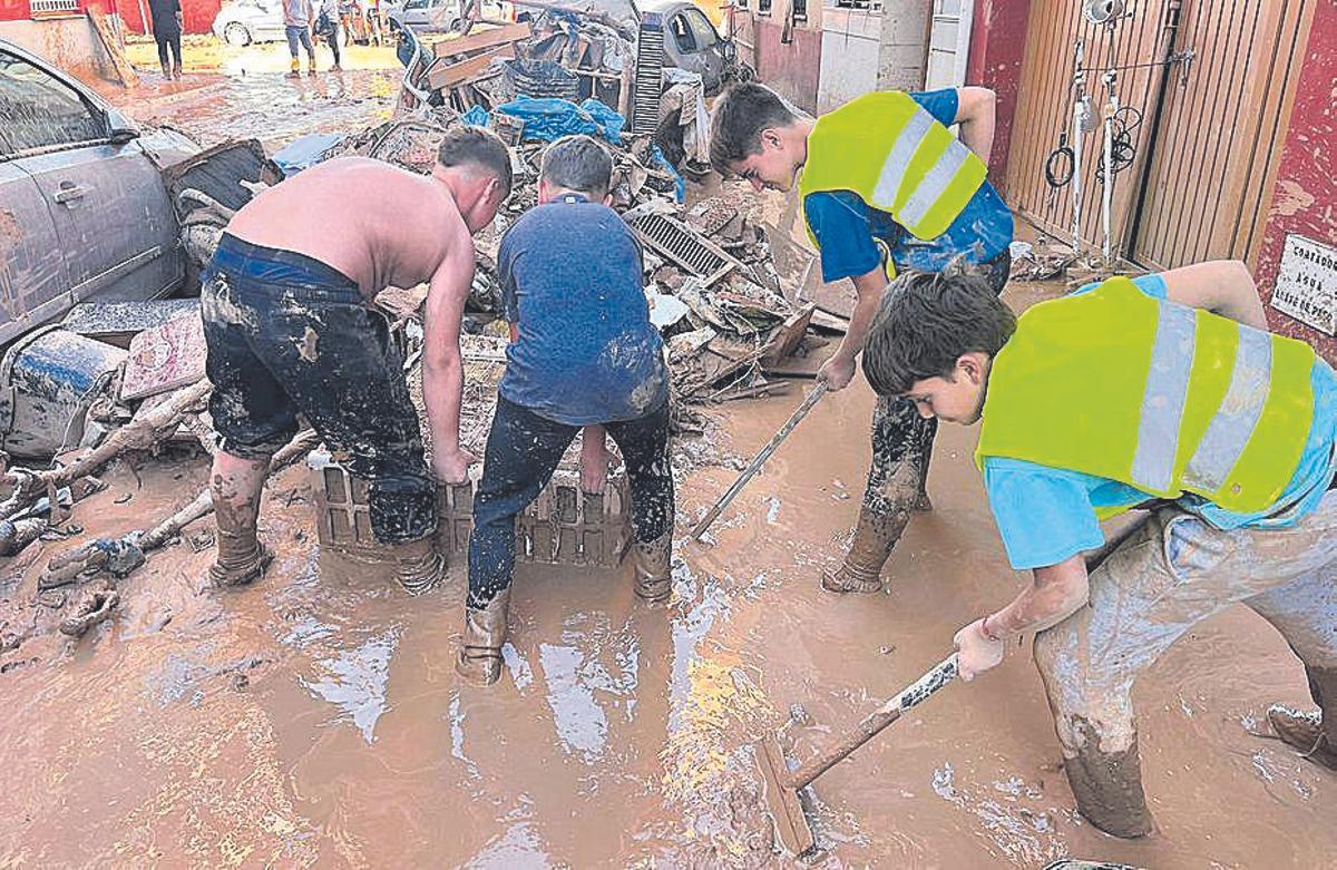 Niños retiran barro de la calles de Massanassa.