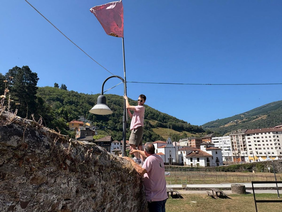 Miembros de la peña "L'Estruendo" colocan su bandera.