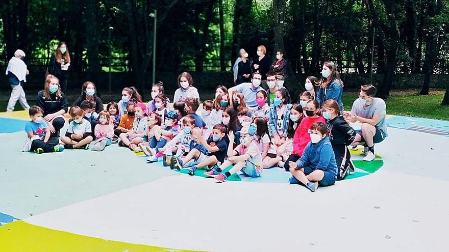 Los niños y niñas, sentados sobre el círculo que pintaron durante el campamento artístico.