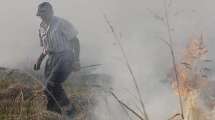 Un agricultor quema la paja del arroz en Corbera, en una imagen de archivo.