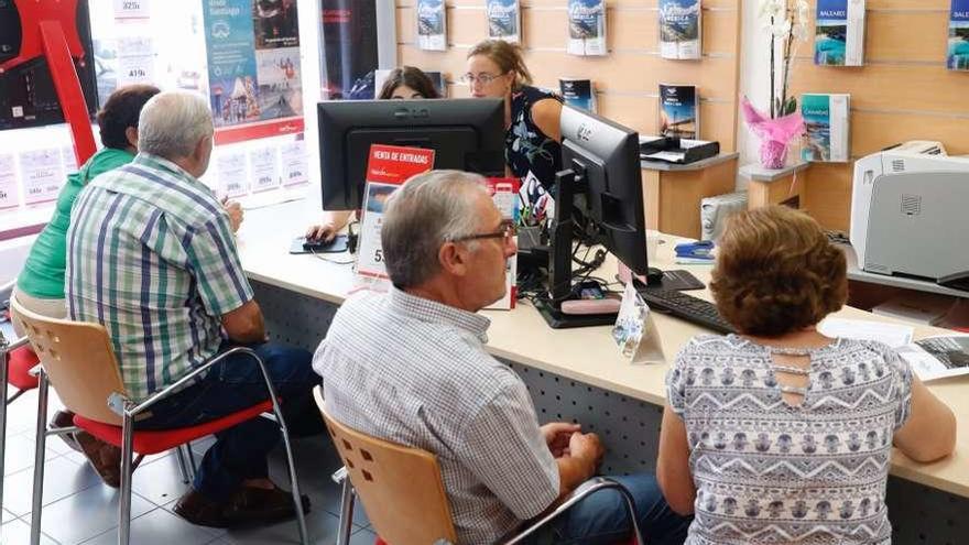 Un grupo de jubilados planifica su viaje del Imserso en una agencia de viajes de Vigo. // José Lores