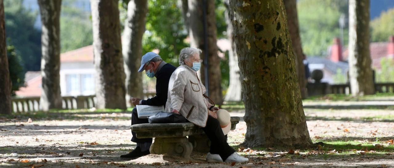 Dos personas mayores sentadas en un banco de la Alameda de Pontevedra.   | // GUSTAVO SANTOS