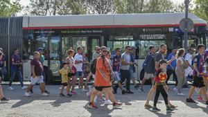 Aficionados del Barça salen de unos de los buses lanzadera fletados hasta Montjuïc.