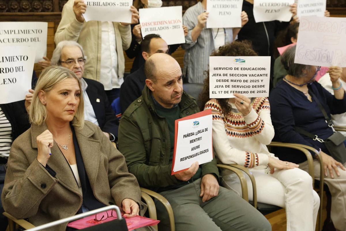 Patricia Manzano, portavoz vecinal de Pumarín, espera su turno para intervenir en el Pleno entre las pancartas de colectivos que denuncian la situación del servicio de ayuda a domicilio, el impago de las primas de jubilación y la situación de la concejalía de Educación.
