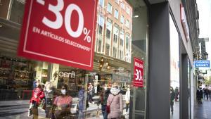 Archivo - Un cartel de rebajas en un escaparate en una calle comercial.