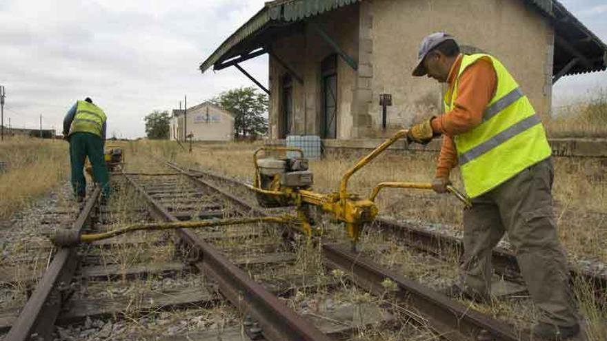 Dos operarios desmantelando la línea férrea en Barcial del Barco hace tres años.