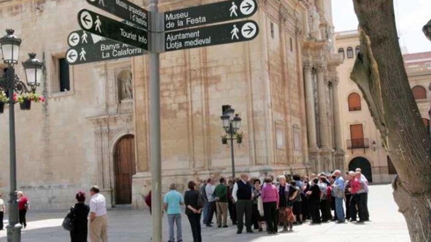 Una excursión de turistas frente a la basílica de Santa María.